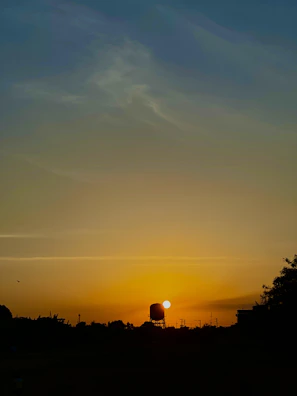 Evening shot of stationary tanks silhouetted against a sunset sky.