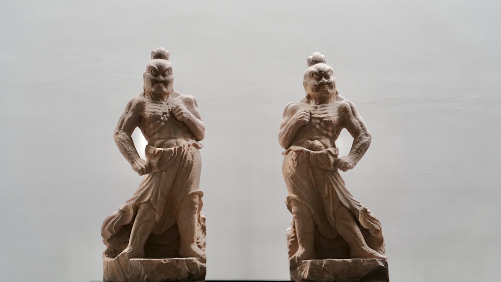 a couple of statues of men standing next to each other