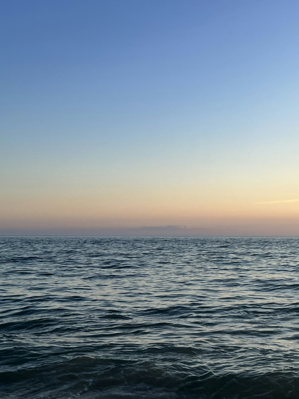 a large body of water sitting under a blue sky