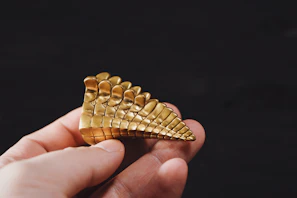 Elegant studio shot of a sculptural object with dramatic shadows and subtle golden accents.