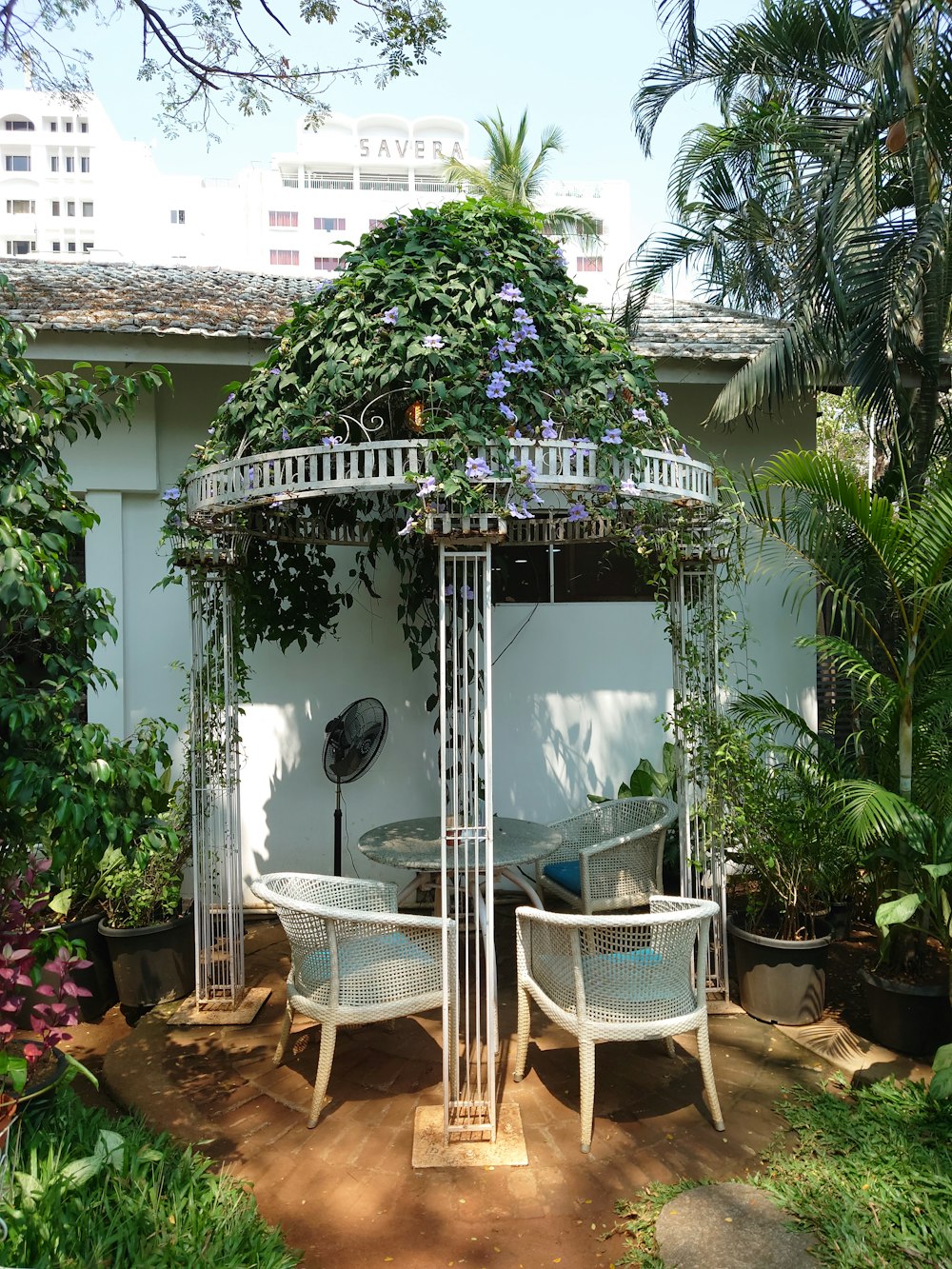 a gazebo with a table and chairs in a garden