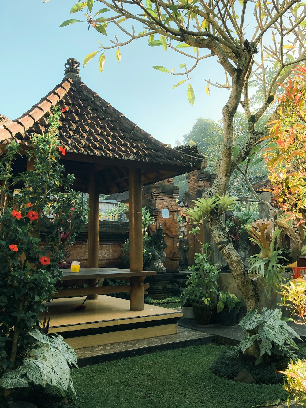 a gazebo in the middle of a lush green garden