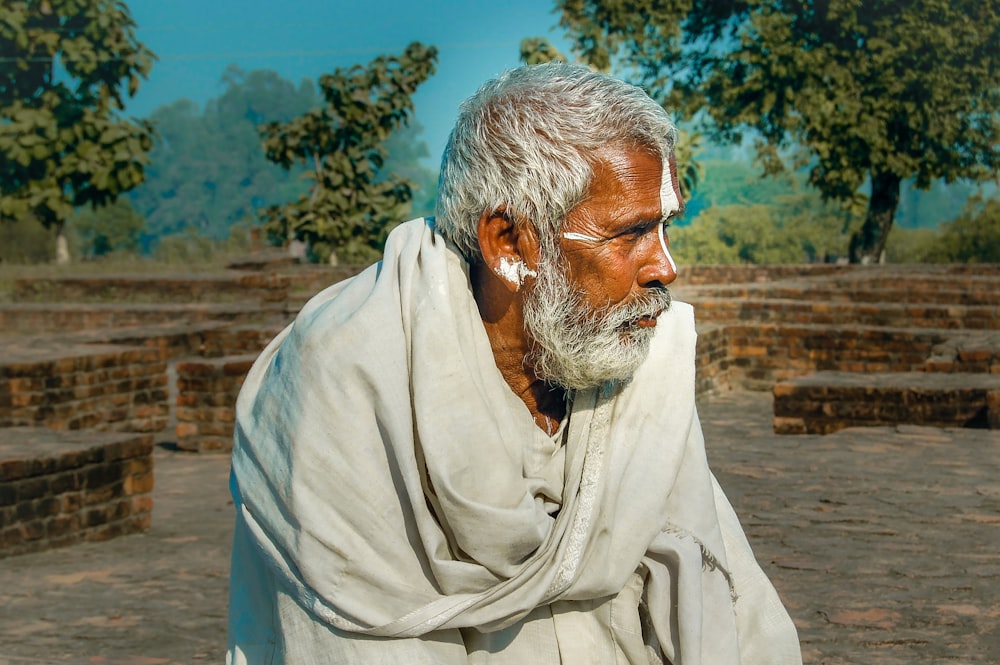 a man with white hair and a beard wearing a white shawl