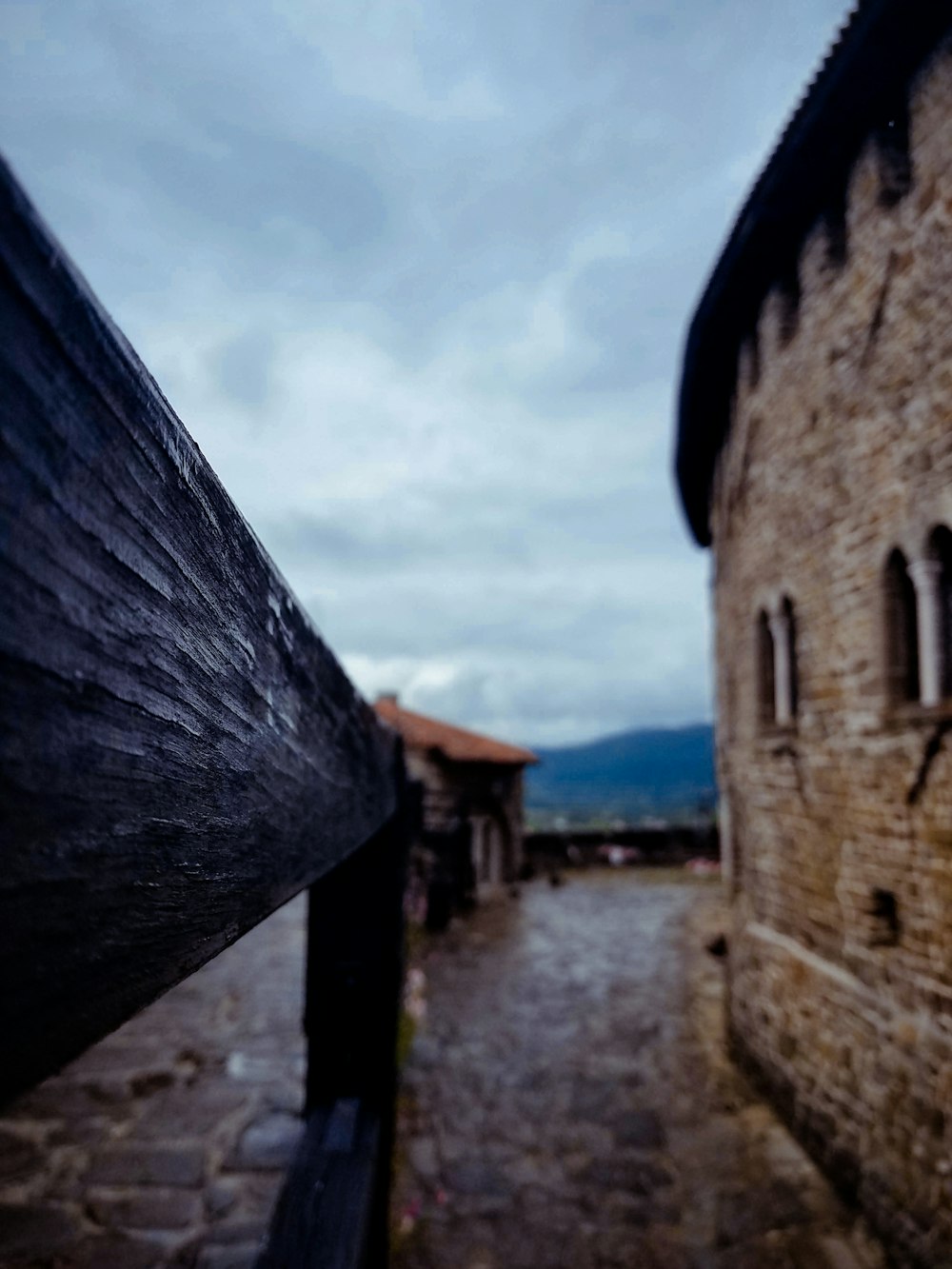 an old brick building with a wooden fence in front of it