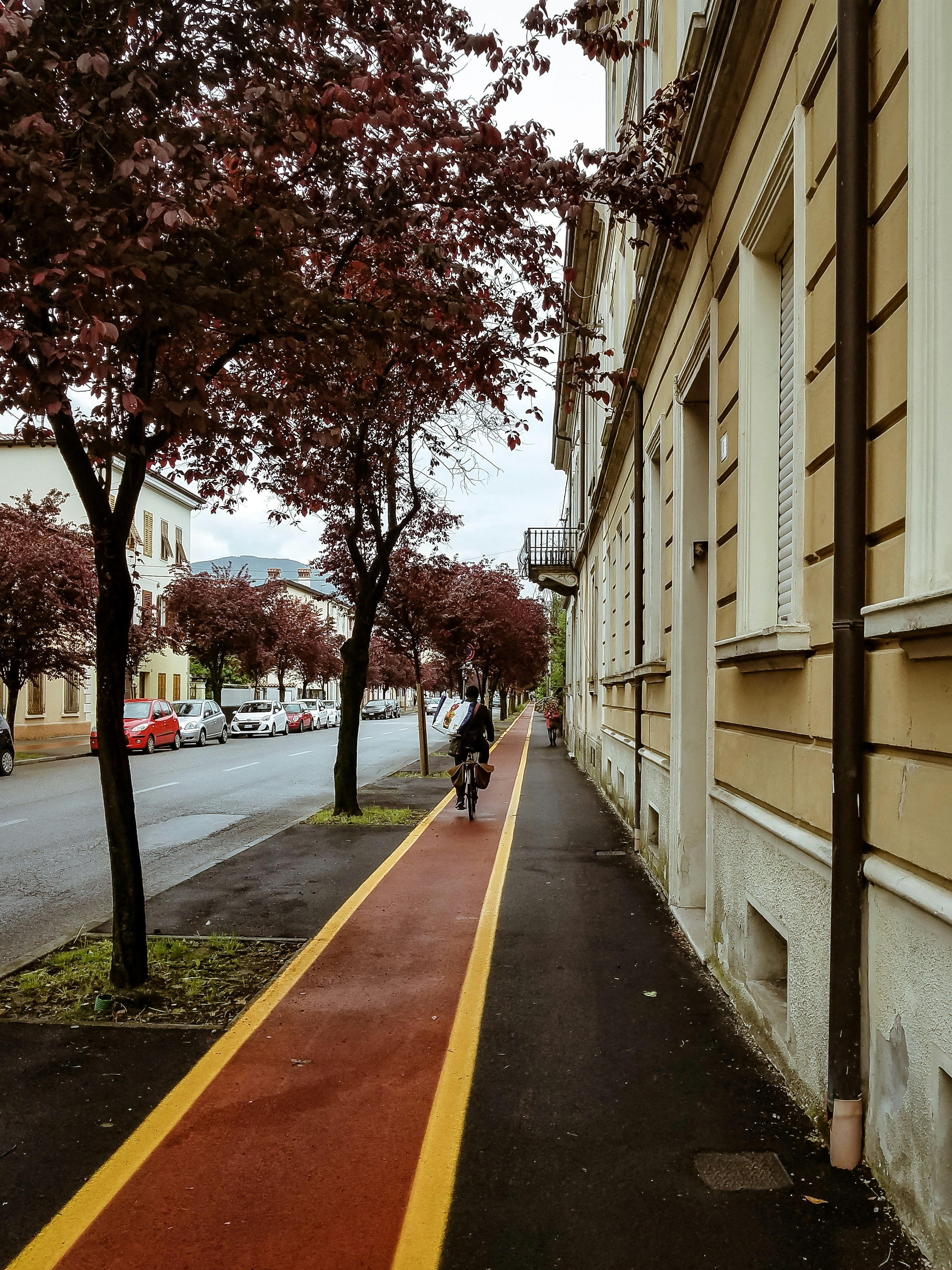 a man riding a bike down a street next to a tall building