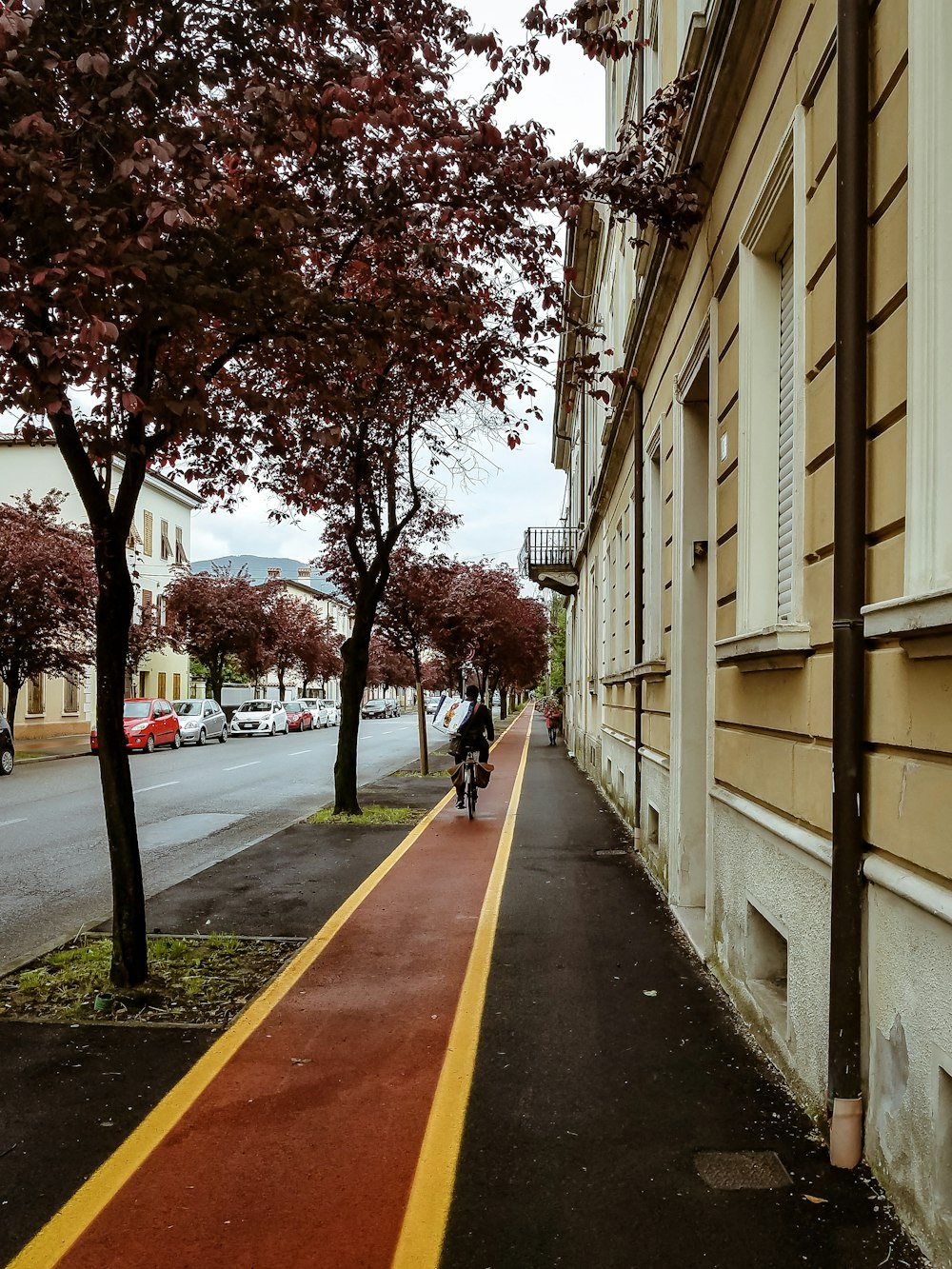 a man riding a bike down a street next to a tall building