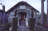 Front view of a cozy two-story house with a small garden.