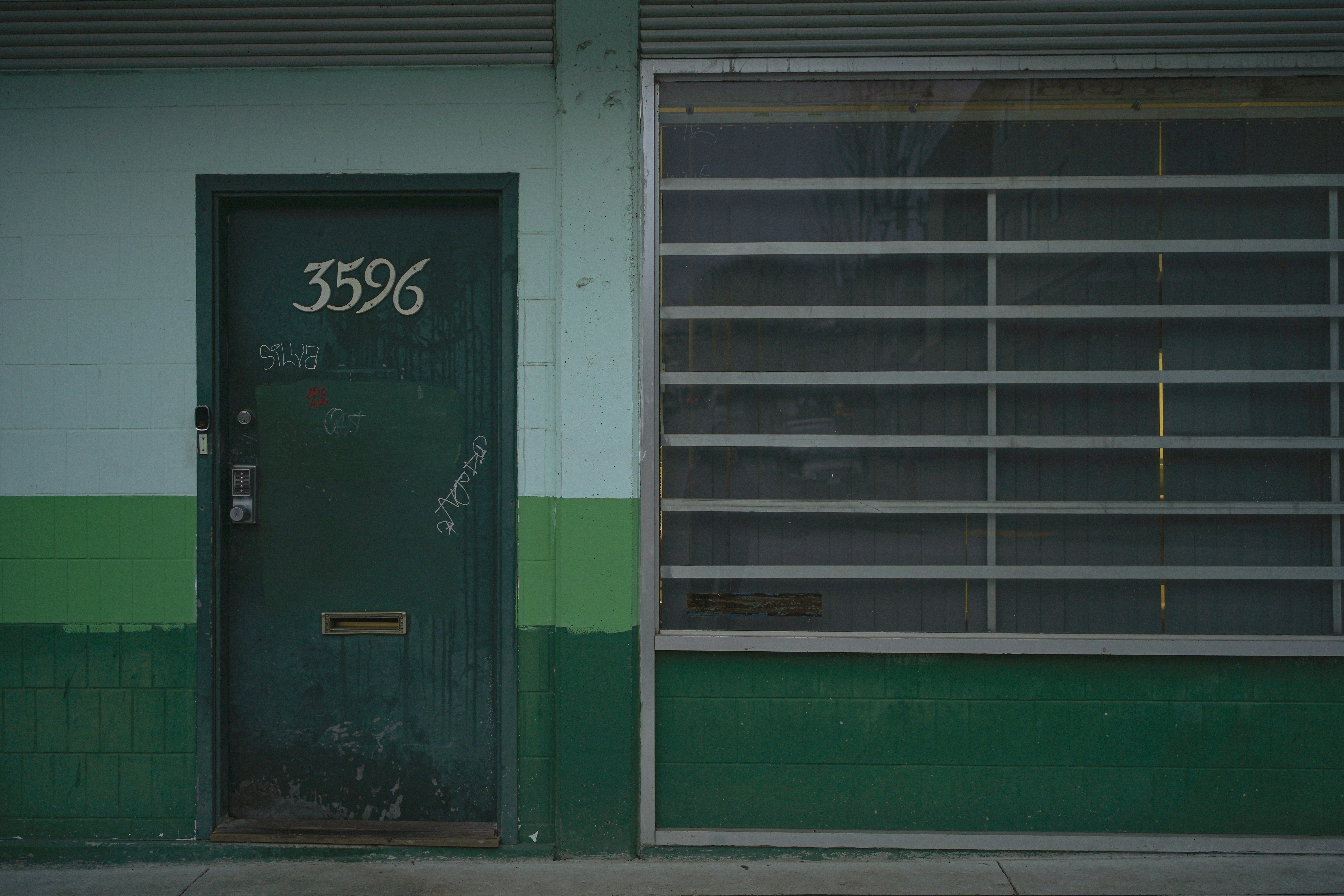 a green door and a green and white building