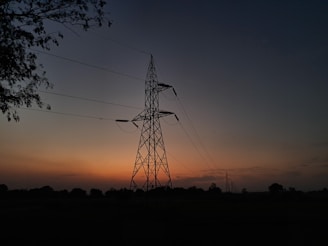the sun is setting behind an electric tower