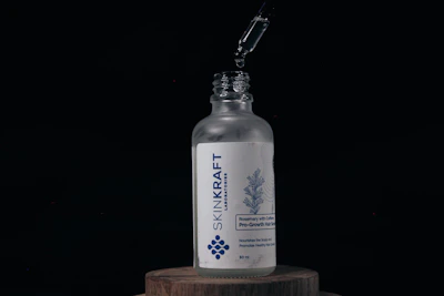 Dark sleek bottle of Black Root Hair Shampoo surrounded by fresh roots and herbs