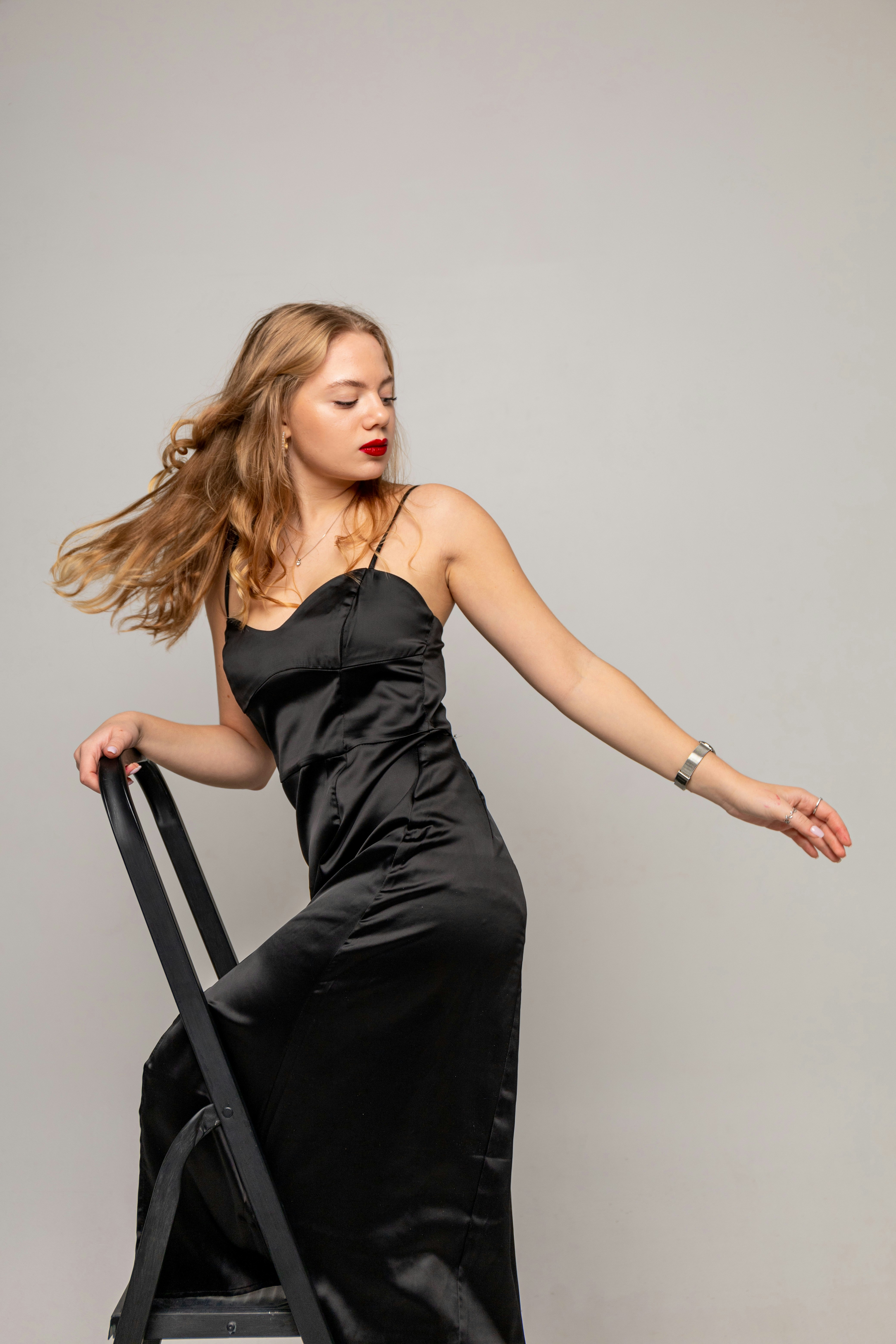 Eine Frau in einem schwarzen Kleid hält einen Koffer