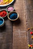 A close-up of colorful herbal powders in small bowls.