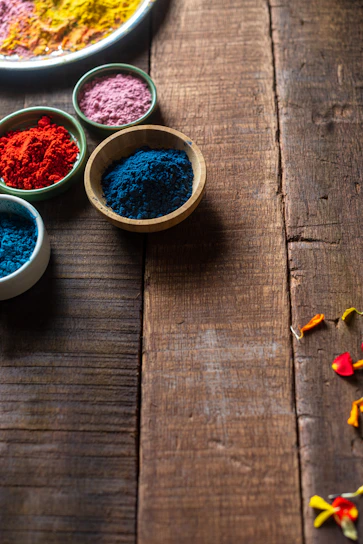 Assortment of colorful podi powders in handcrafted bowls with sunray patterns casting warm light.