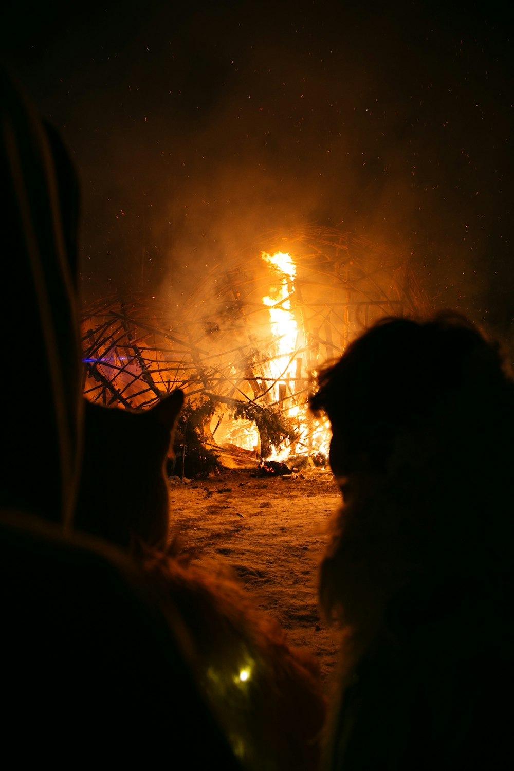 a group of people standing in front of a fire