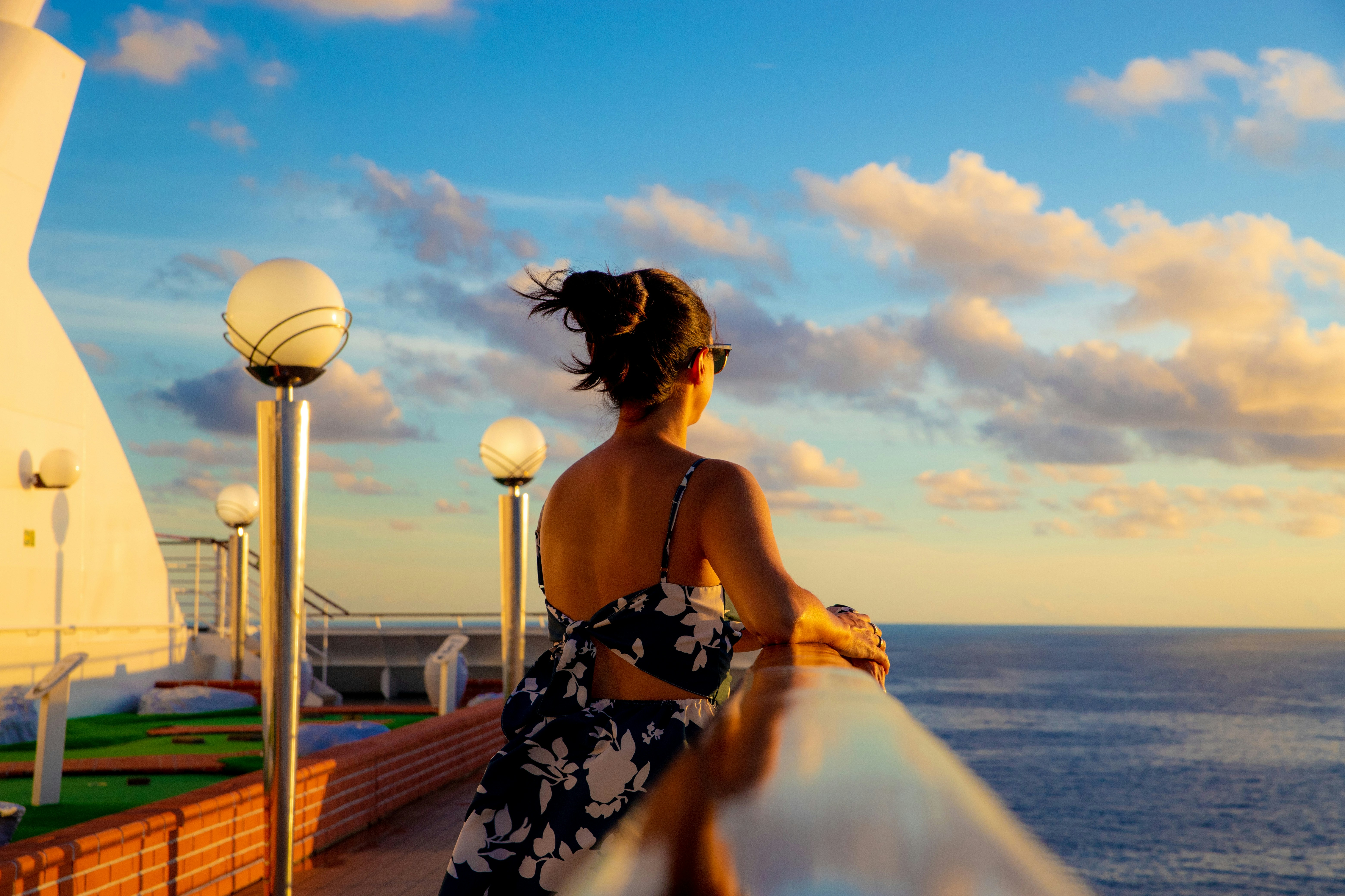 a woman standing on a balcony looking out at the ocean