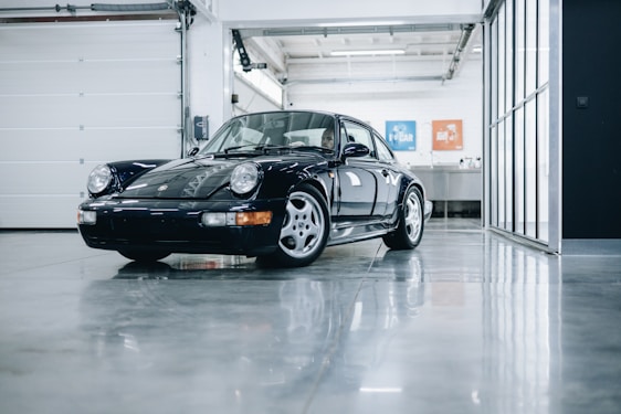 A well-maintained car in a modern garage with natural light highlighting its polished surface.