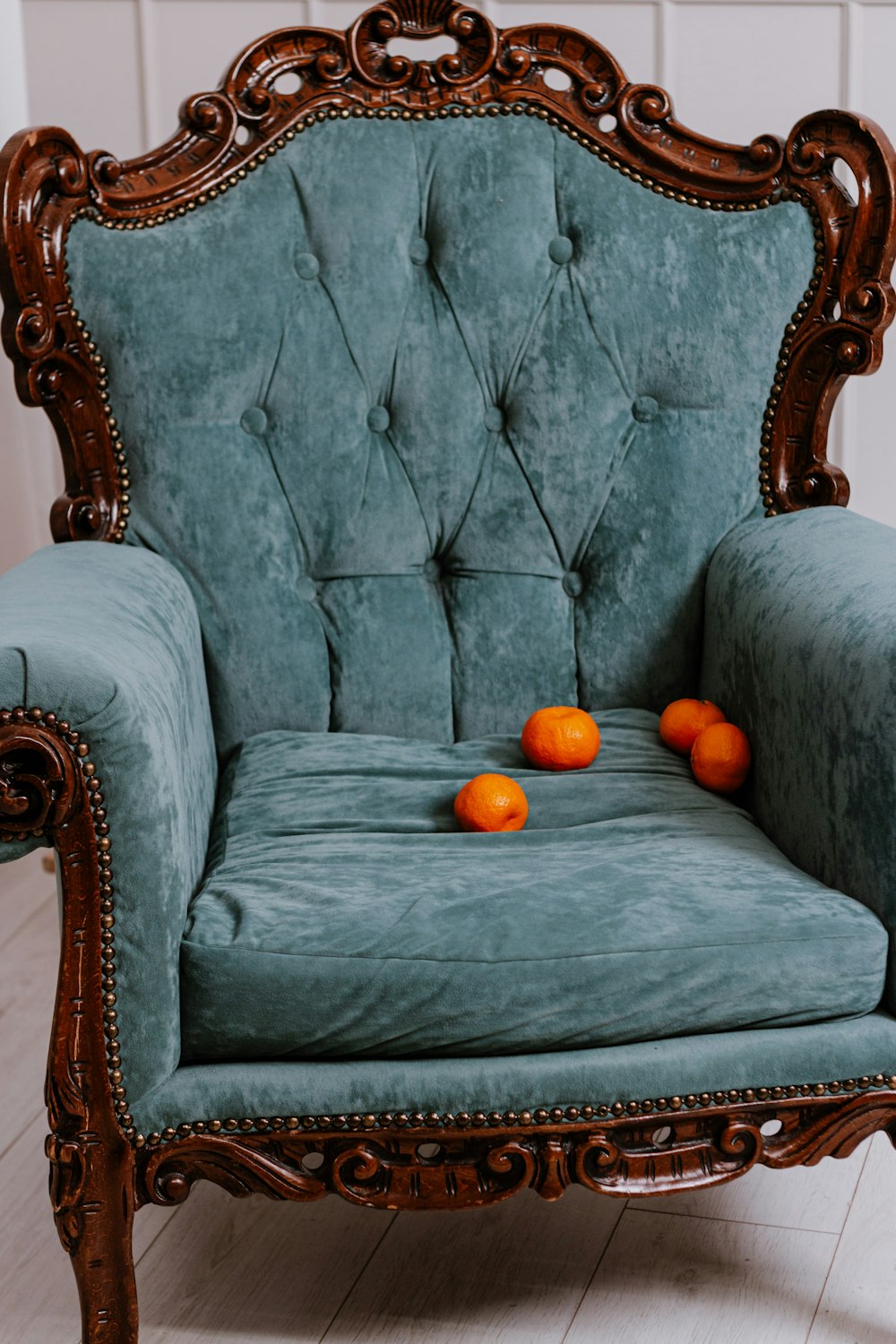 a blue velvet chair with oranges on it
