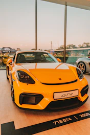 a yellow sports car parked in a showroom