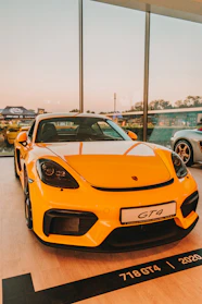 a yellow sports car parked in a showroom