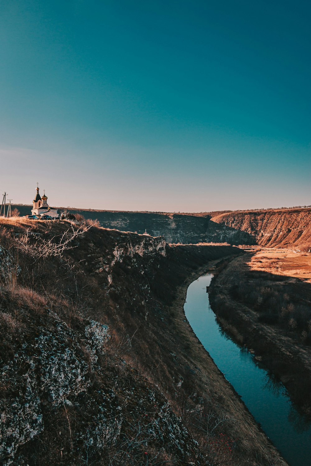 a man standing on top of a hill next to a river