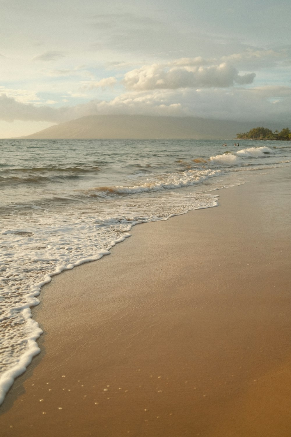 a sandy beach with waves coming in to shore