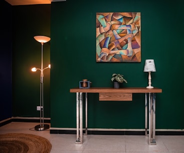 Interior wall being carefully painted in a modern home with oak flooring and forest green accents.