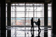 Construction workers collaborating on a residential building site with blueprints.