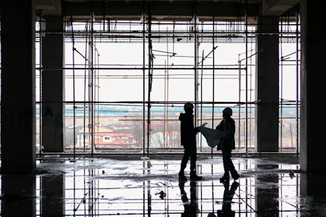 Engineer inspecting blueprints on a modern construction site.