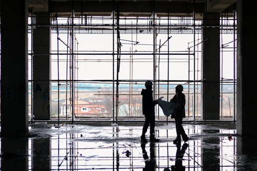 A modern construction site with workers discussing blueprints.