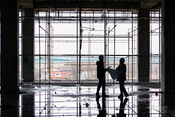 Industrial construction site with workers reviewing blueprints on location.