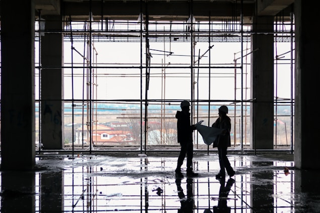 A construction consultant reviewing blueprints on a job site.