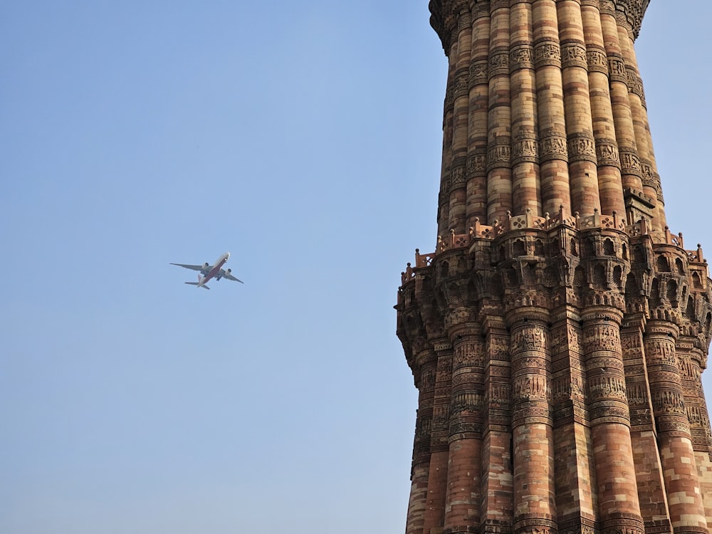 an airplane is flying over a tall tower