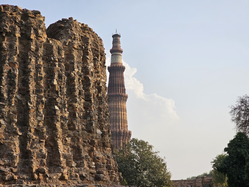 a tall tower next to a stone wall