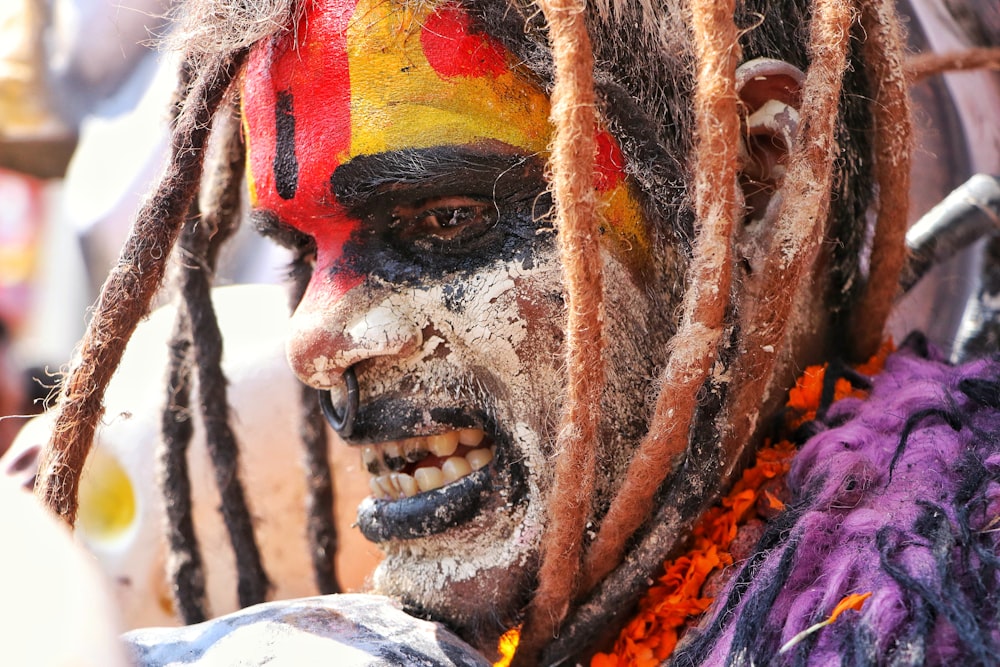 a close up of a person with dreads and makeup