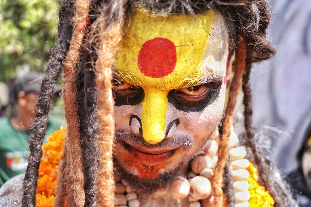 a man with dreadlocks and a painted face