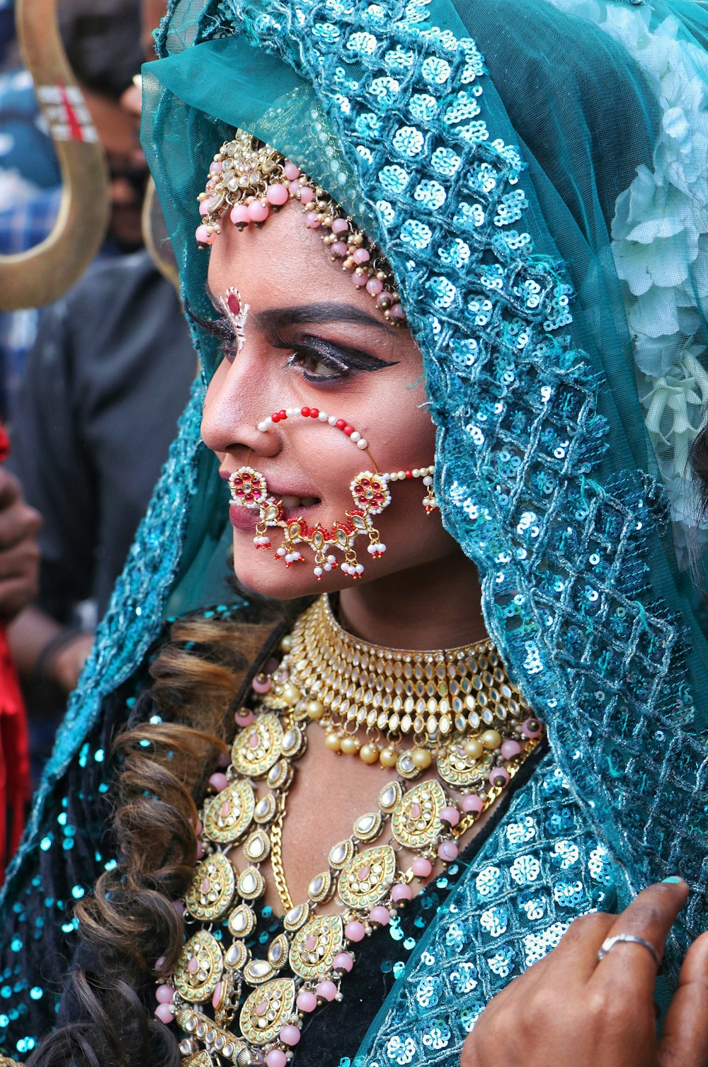 a woman wearing a blue veil and jewelry