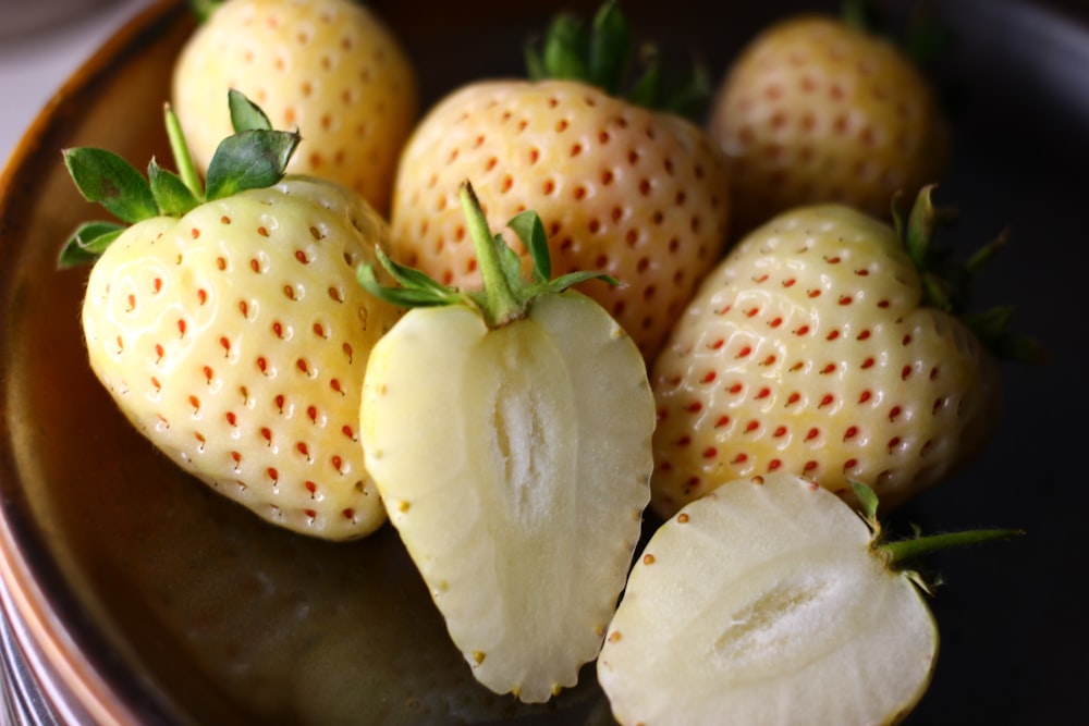 a close up of a plate of strawberries on a table