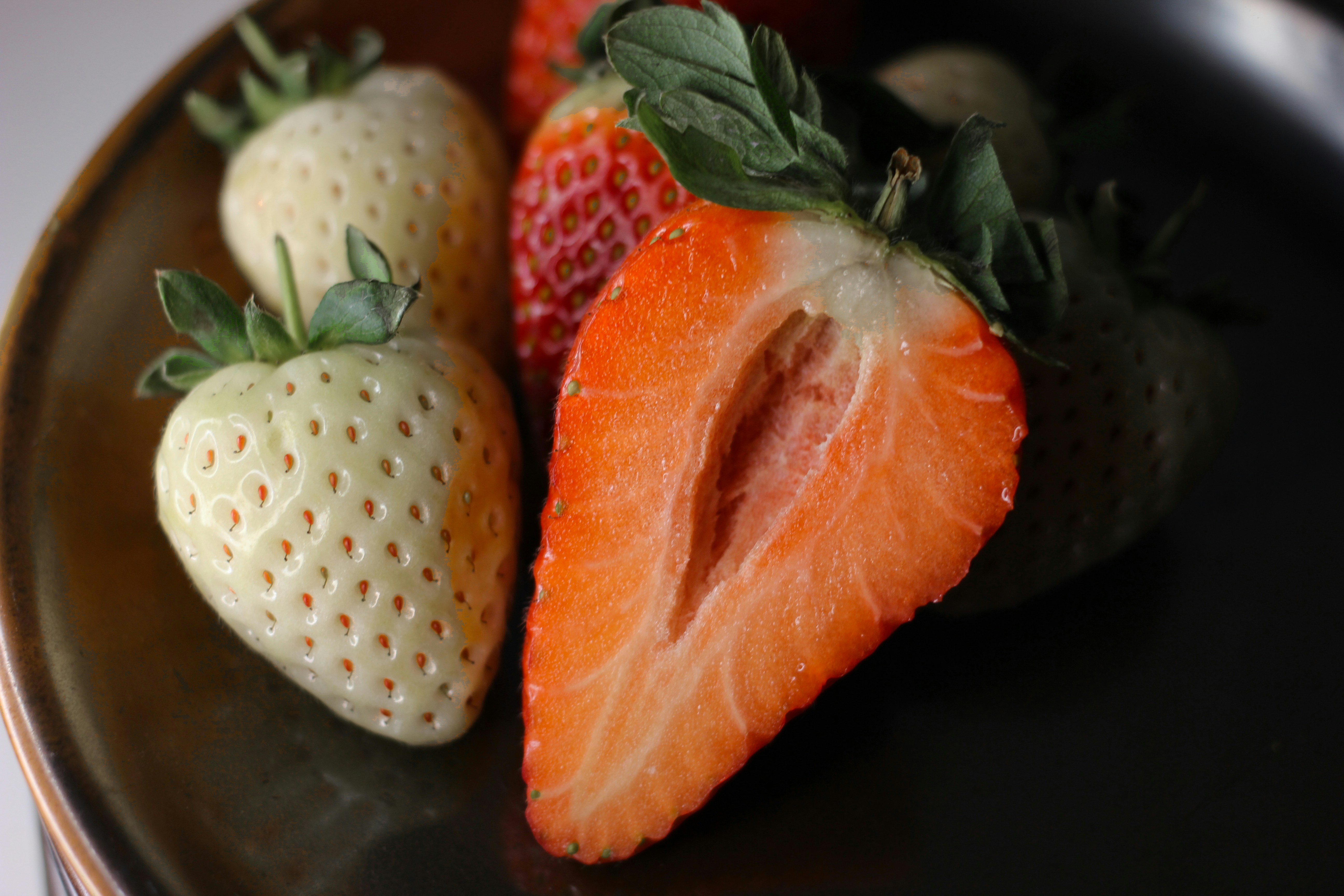 a plate of strawberries and a strawberry on a table
