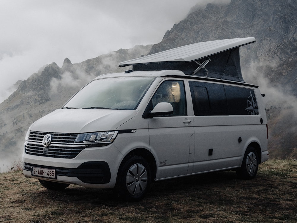 a white van parked in front of a mountain