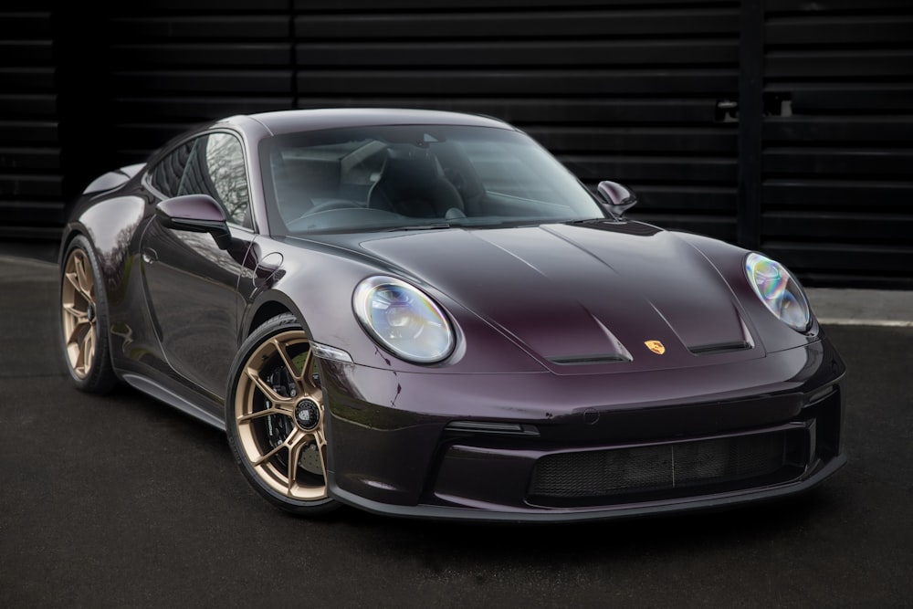 a purple sports car parked in front of a garage