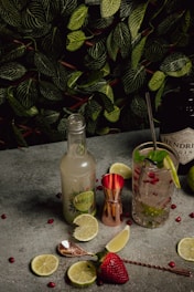 a table topped with two bottles of alcohol and a strawberry