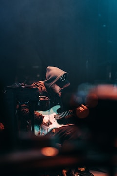 A serene performance scene with a guitarist and electronic setup.