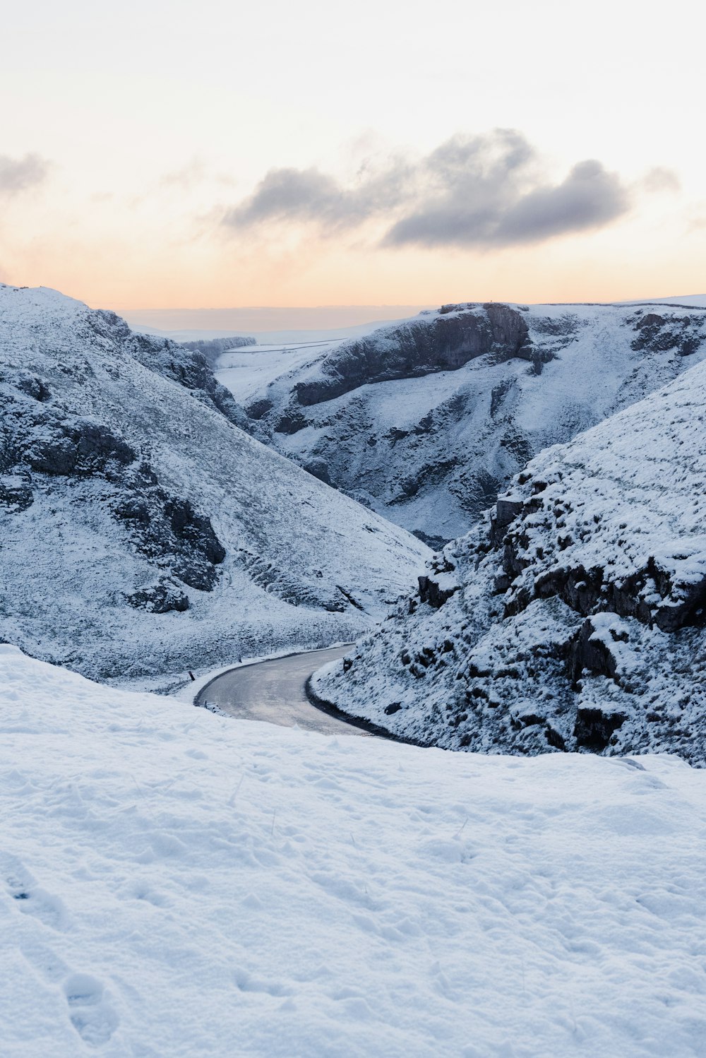 a snowy mountain with a winding road in the middle