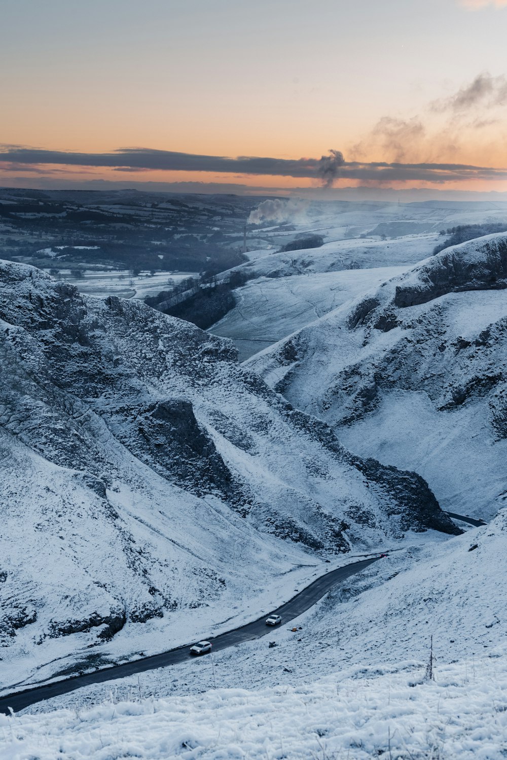 a snow covered mountain with a road going through it