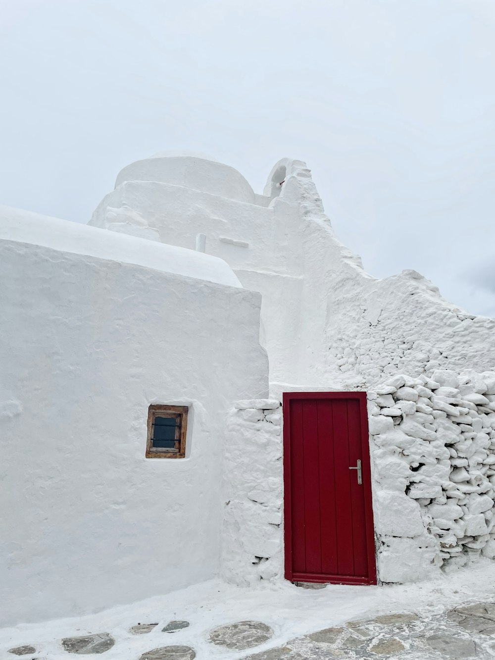 a red door is open on a white building