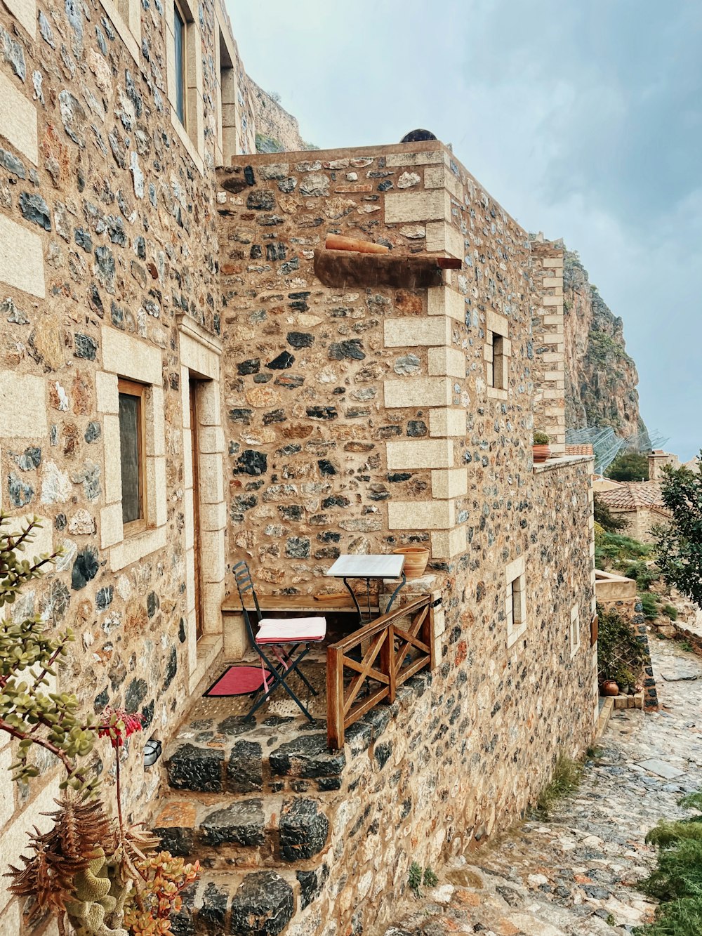 a stone building with a table and chairs on it