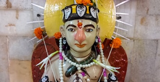 A detailed marble statue of a deity adorned with intricate carvings and serene expression.