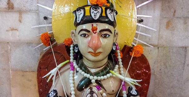 A detailed marble statue of a deity adorned with intricate carvings and serene expression.