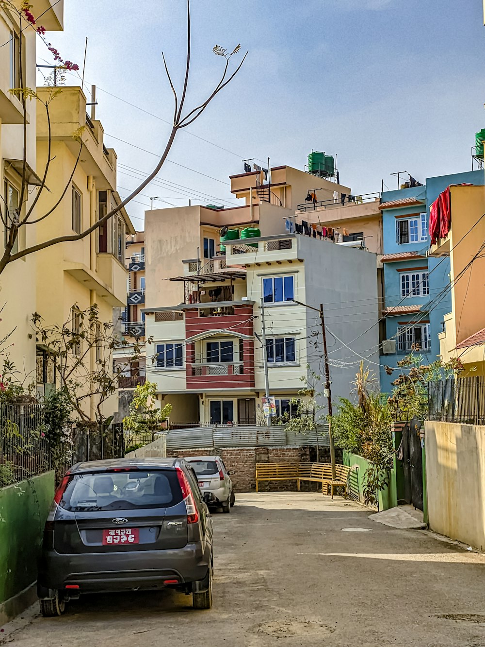 a car parked on the side of a road next to tall buildings