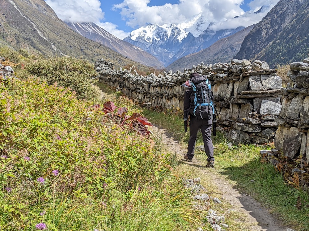 a man with a backpack walking up a trail